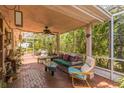 Cozy covered patio with brick flooring, comfortable seating, and screened enclosure at 251 Tropic W Blvd, Largo, FL 33770