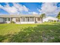 Expansive lawn with an enclosed patio providing a bright, airy space, ideal for enjoying outdoor living at 2015 Gardenia Landings Ln, Sun City Center, FL 33573