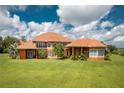Rear exterior showcasing spacious lawn and architectural details at 37511 Washington Loop Road, Punta Gorda, FL 33982