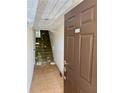 Entryway with tiled floor, carpeted stairs, and an entrance door at 115 1St E St # 103, Tierra Verde, FL 33715