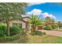 Well-maintained home boasting lush landscaping, a brick paver driveway, and mature trees, offering a welcoming and serene atmosphere at 12784 Burns Dr, Odessa, FL 33556