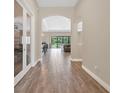 Inviting hallway featuring neutral walls, stylish wood-look tile flooring, and archways, leading to the various living spaces at 12784 Burns Dr, Odessa, FL 33556