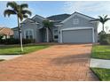 Charming single-story house with a two-car garage, a paved driveway, and tropical landscaping in the front yard at 1751 Bobcat Trl, North Port, FL 34288