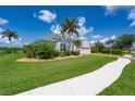 Well-manicured lawn with a single-story home, mature trees, and a paved walkway leading to the entrance at 1751 Bobcat Trl, North Port, FL 34288