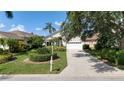 Inviting single-Gathering home showcasing a well-maintained lawn, mature trees, and a spacious driveway at 6504 Virginia Xing, University Park, FL 34201