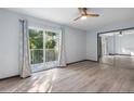 A bedroom with mirrored closet doors, balcony, and wood-look laminate flooring at 11239 Cedar Hollow Ln, Tampa, FL 33618