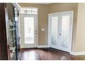 A bright entryway with hardwood floors, double glass doors, and a clear view of the front door at 9221 Mountain Magnolia Dr, Riverview, FL 33578