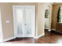 Entryway featuring light tan walls, white trim, hardwood floors, and double doors with decorative glass at 9221 Mountain Magnolia Dr, Riverview, FL 33578
