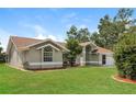 Side view of a single Gathering home featuring lush green grass and mature trees at 4266 Candler Ave, Spring Hill, FL 34609