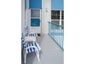 Balcony with outdoor seating, white chairs with blue stripes, and gray flooring at 215 Medallion Blvd # G, Madeira Beach, FL 33708