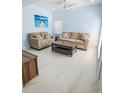 Light blue living room with comfortable seating, a ceiling fan, and bright, natural light at 215 Medallion Blvd # G, Madeira Beach, FL 33708