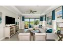 Bright living room featuring elegant decor, comfortable seating, and views of outdoor scenery through large windows at 3142 Torta Ct, Bradenton, FL 34211