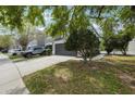 Charming townhome featuring a two-car garage, driveway, and well-kept lawn with mature trees at 10124 Westpark Preserve Blvd, Tampa, FL 33625