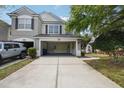 View of the home's garage and driveway with ample storage space inside and a manicured lawn outside at 10124 Westpark Preserve Blvd, Tampa, FL 33625
