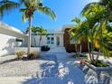 Stunning modern home with beautiful landscaping, white gravel, and a paver walkway leading to the entrance at 2408 Nassau St, Sarasota, FL 34231