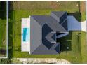 Aerial view of a single-Gathering home featuring a pool, black roof, and manicured lawn at 9257 King Hill St, Port Charlotte, FL 33981
