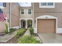 Two-story townhome with a one-car garage and landscaped walkway at 26622 Castleview Way, Wesley Chapel, FL 33544