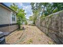 Fenced backyard with ample space and a cement wall, providing privacy and potential for outdoor activities at 1711 E Sewaha St, Tampa, FL 33612