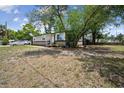 A cozy home surrounded by lush greenery and a well-maintained lawn, complemented by a car parked on the side at 1711 E Sewaha St, Tampa, FL 33612