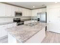 This kitchen offers granite countertops, stainless steel appliances, an island, and plenty of storage at 3124 N Chamberlain Blvd, North Port, FL 34286