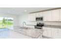 Bright kitchen features granite countertops, stainless steel appliances, and ample cabinet space at 3124 N Chamberlain Blvd, North Port, FL 34286