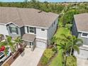 Aerial view of a two-story home with an attached garage, a well-manicured lawn, and mature trees at 8661 Daydream St, Sarasota, FL 34238