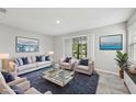 Bright living room featuring modern furniture, stylish decor, and sliding glass doors to outdoor space at 8661 Daydream St, Sarasota, FL 34238