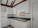 Cozy kitchen featuring white cabinets, sleek countertops, and a bright window at 5641 Ashley Oaks Dr # 39, Tampa, FL 33617