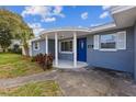 Beautiful home featuring a rounded porch, blue front door, neutral paint, and well-maintained landscaping at 1035 S Duncan Ave, Clearwater, FL 33756