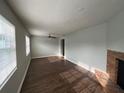 Bright living room featuring wood floors, a ceiling fan, a brick fireplace, and abundant natural light at 1035 S Duncan Ave, Clearwater, FL 33756