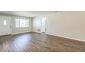 Bright living room with wood-look flooring, neutral paint, white trim, and a large window at 1035 S Duncan Ave, Clearwater, FL 33756