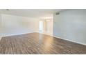 Spacious living room with wood-look flooring and neutral paint; opens to dining area with tile floors at 1035 S Duncan Ave, Clearwater, FL 33756