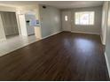 Open living room with wood floors, a view of the kitchen, and natural light from a front window at 1035 S Duncan Ave, Clearwater, FL 33756