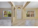 Bright foyer featuring neutral tile flooring, natural light from windows, and a welcoming entryway at 14256 Salvatierra Ln, Port Charlotte, FL 33981