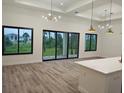 Open floor plan features a kitchen flowing into the living room, large windows, and sliding glass doors at 14914 San Domingo Blvd, Port Charlotte, FL 33981