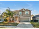Inviting two-story home with a manicured lawn, palm tree, and attached garage at 8506 Hunters Fork Loop, Ruskin, FL 33573