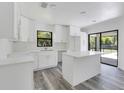 Bright white kitchen featuring an island, modern fixtures, and plenty of cabinet space at 19543 Midway Blvd, Port Charlotte, FL 33948