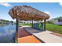 Relaxing tiki hut on the water with a concrete slab and wooden pier at 24277 Treasure Island Blvd, Punta Gorda, FL 33955