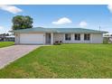 Charming single-story home with a well-manicured lawn and a paved driveway at 24277 Treasure Island Blvd, Punta Gorda, FL 33955