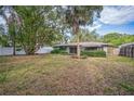 Spacious backyard with mature trees, a patio, and a white fence at 101 N Nimbus Ave, Clearwater, FL 33765