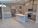 Modern kitchen boasts stainless steel appliances, a center island, and ample cabinet space at 12513 Oak Hill Way, Parrish, FL 34219