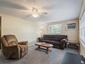 Cozy living room featuring comfortable seating, neutral carpet, and a ceiling fan at 20703 Old Trilby Rd, Dade City, FL 33523