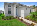 Inviting home with a white facade, manicured lawn, and a walkway leading to the bright blue entrance door at 28761 Sweet Persimmon Dr, Wesley Chapel, FL 33543