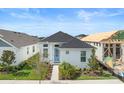 Well-maintained home featuring a classic white exterior, complemented by lush landscaping and a striking blue door at 28761 Sweet Persimmon Dr, Wesley Chapel, FL 33543