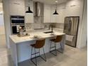 Modern kitchen with stainless steel appliances, an island, and a marble backsplash at 10153 Wildcat St, Port Charlotte, FL 33981