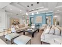 A stylish living room features modern decor, comfortable seating, and sophisticated lighting with tranquil blue accent wall at 3010 Grand Bay Blvd # 472, Longboat Key, FL 34228