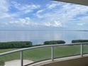 Balcony view showcases expansive water views with lush green space below, creating a serene retreat at 3010 Grand Bay Blvd # 472, Longboat Key, FL 34228