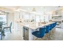 Bright kitchen features white cabinets, granite countertops, a wine cooler, and bar seating at 328 6Th Ave, Indian Rocks Beach, FL 33785