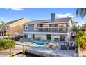 Beautiful two-story home with a backyard pool, canal access, and a waterfront patio with outdoor seating at 328 6Th Ave, Indian Rocks Beach, FL 33785