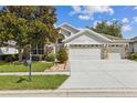 Beautiful single-story home with a three-car garage, stone accents, and lovely landscaping at 6935 Runner Oak Dr, Wesley Chapel, FL 33545